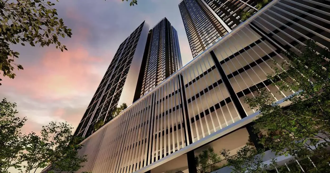 Aras Residences twin towers at dusk seen from the tree line, vertical bronze fins against a lavender sky