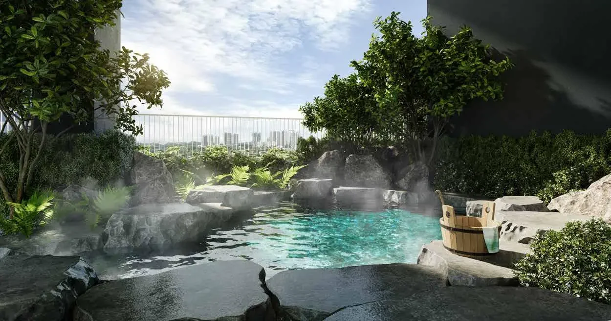 Onsen-style warm pool at Aras Residences set among rocks and greenery